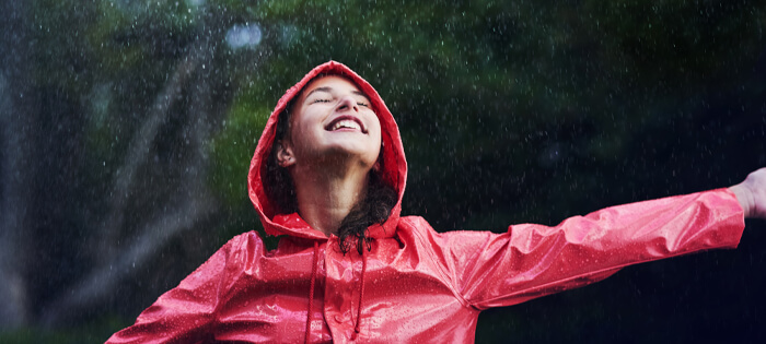 A smiling person in a red waterproof coat